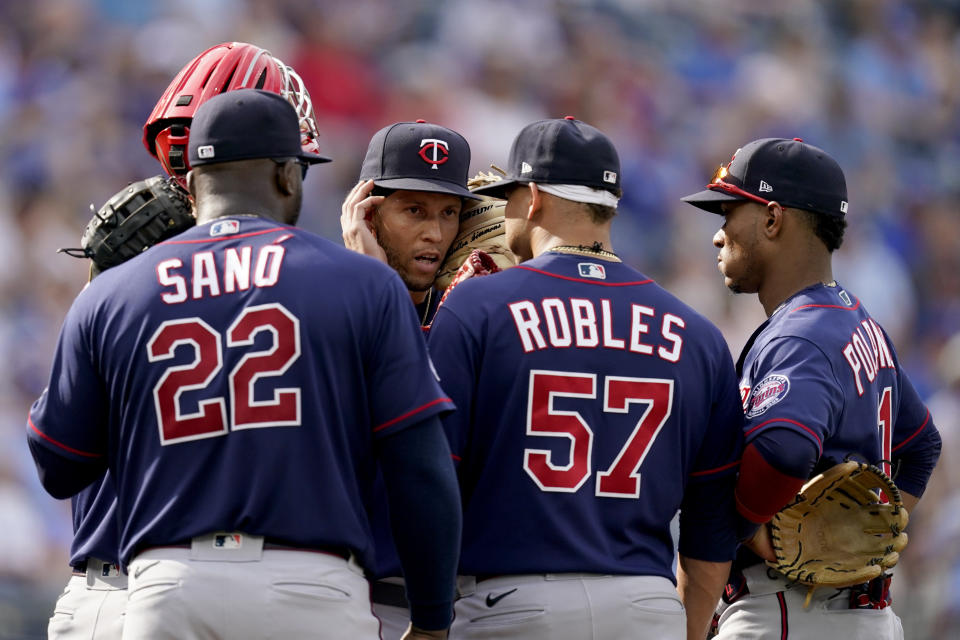 Minnesota Twins shortstop Andrelton Simmons, center, talks to teammates during a meeting on the mound during the ninth inning of a baseball game against the Kansas City Royals Saturday, June 5, 2021, in Kansas City, Mo. The Twins won 5-4. (AP Photo/Charlie Riedel)