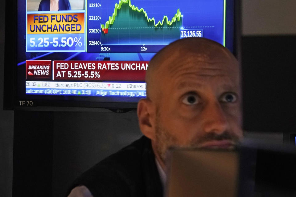 File - A news report shows the Federal Reserve's rate decision as Specialist Meric Greenbaum works on the floor of the New York Stock Exchange, Nov. 1, 2023. Confidence is growing among Federal Reserve officials and many economists that high interest rates and healed supply chains will soon defeat inflation. (AP Photo/Richard Drew, File)