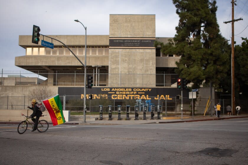 LOS ANGELES, CA - JANUARY 12: A supporter rides around with a Black Lives Matter flag at a news conference at the the Men's Central Jail organized by Black Lives Matter -- Los Angeles and Justice X calling for justice for Jalani Lovett on Wednesday, Jan. 12, 2022 in Los Angeles, CA. (Jason Armond / Los Angeles Times)