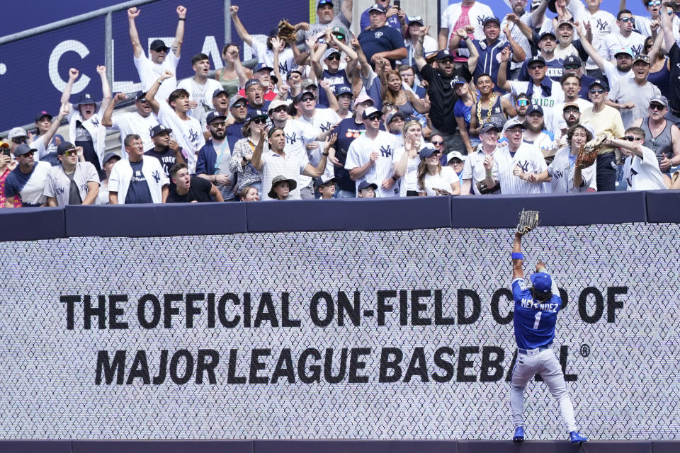 Kansas City Royals' right fielder MJ Melendez (1) reaches for the ball as a fan, right, catches New York Yankees' Aaron Judge's two-run home run during the second inning of a baseball game, Saturday, July 30, 2022, in New York. (AP Photo/Mary Altaffer)