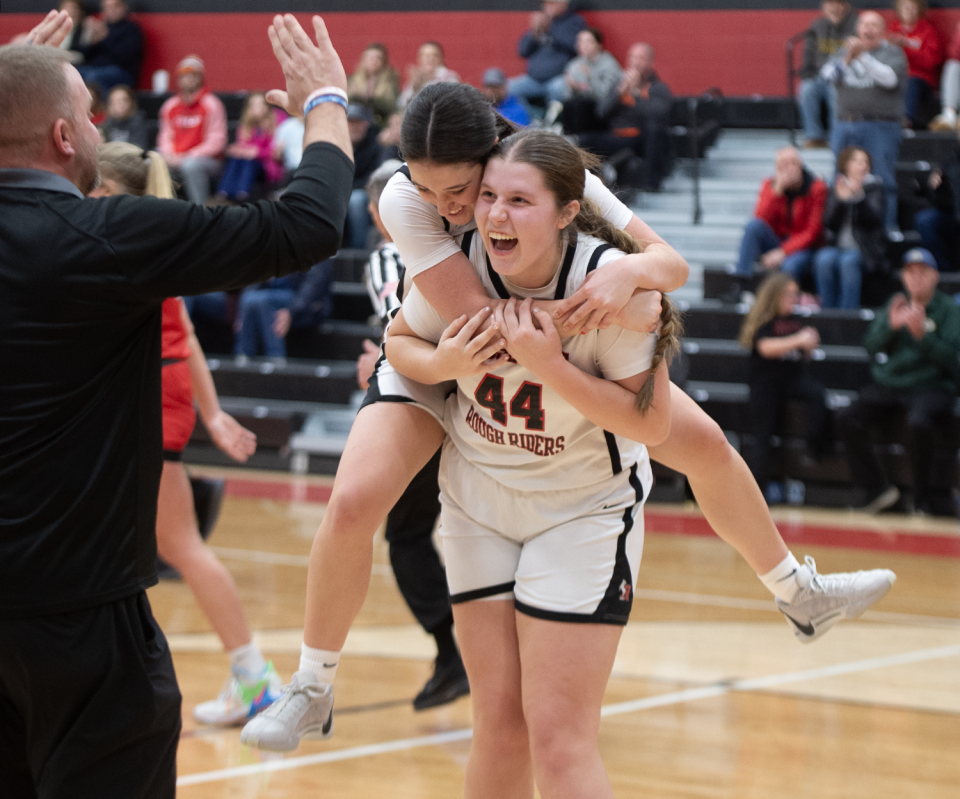 Kent Roosevelt head coach Craig Foreman greets Julia Nash and Claire VanDamme walking off the court after a Rough Riders win.