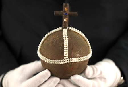 Stephen Lane, CEO of Prop Store, poses for a photograph with the Holy Hand Grenade of Antioch from the film "Monty Python and the Holy Grail" at a preview of a film and tv memorabilia sale in London