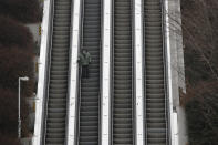 A man wearing a face mask as a precaution against the coronavirus takes the escalator down in Seoul, South Korea, Sunday, Dec. 13, 2020. (AP Photo/Lee Jin-man)