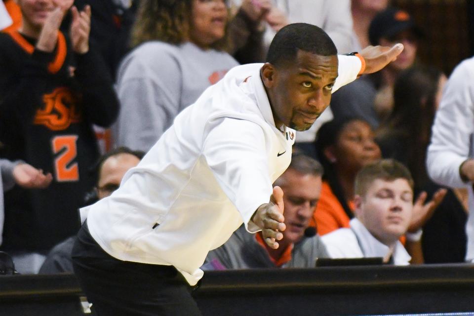 Oklahoma State head coach Mike Boynton, Jr. signals to his team during the first half of an NCAA college basketball game Saturday, Feb. 19, 2022, in Stillwater, Okla. Oklahoma State defeated Kansas State 82-79 in overtime. (AP Photo/Brody Schmidt)