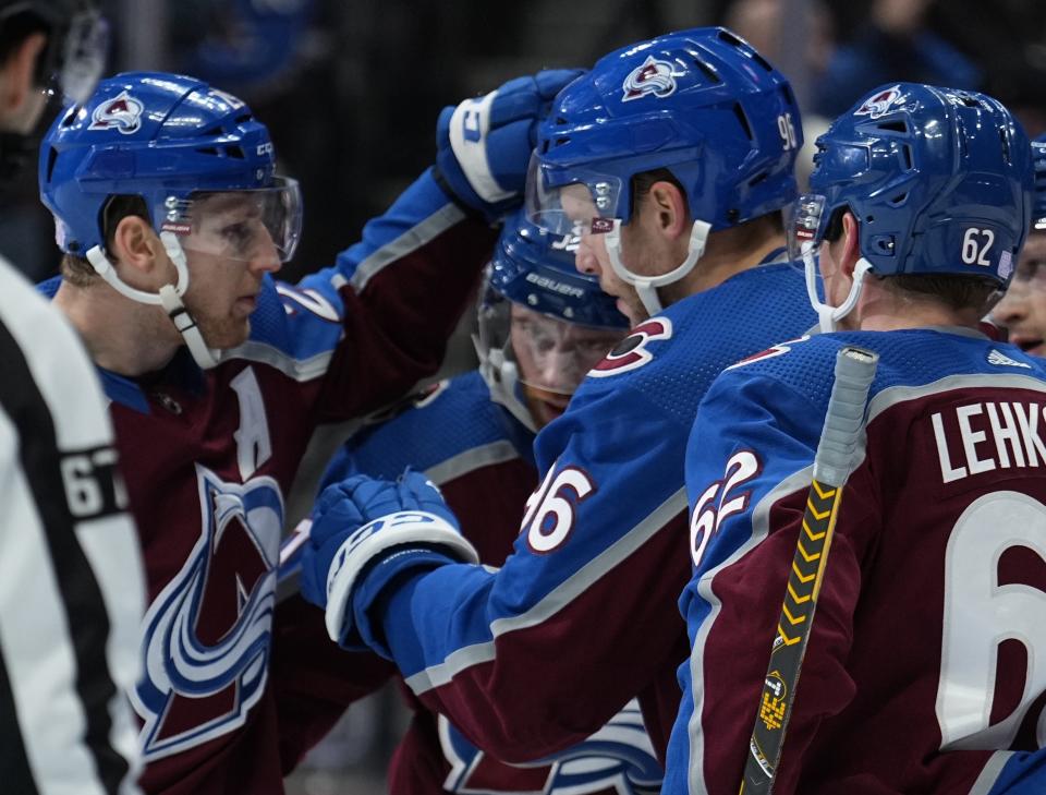 Colorado Avalanche right wing Mikko Rantanen (96) celebrates with teammates after his second goal of the night against the Vancouver Canucks, during the first period of an NHL hockey game Wednesday, Nov. 23, 2022, in Denver. (AP Photo/Jack Dempsey)