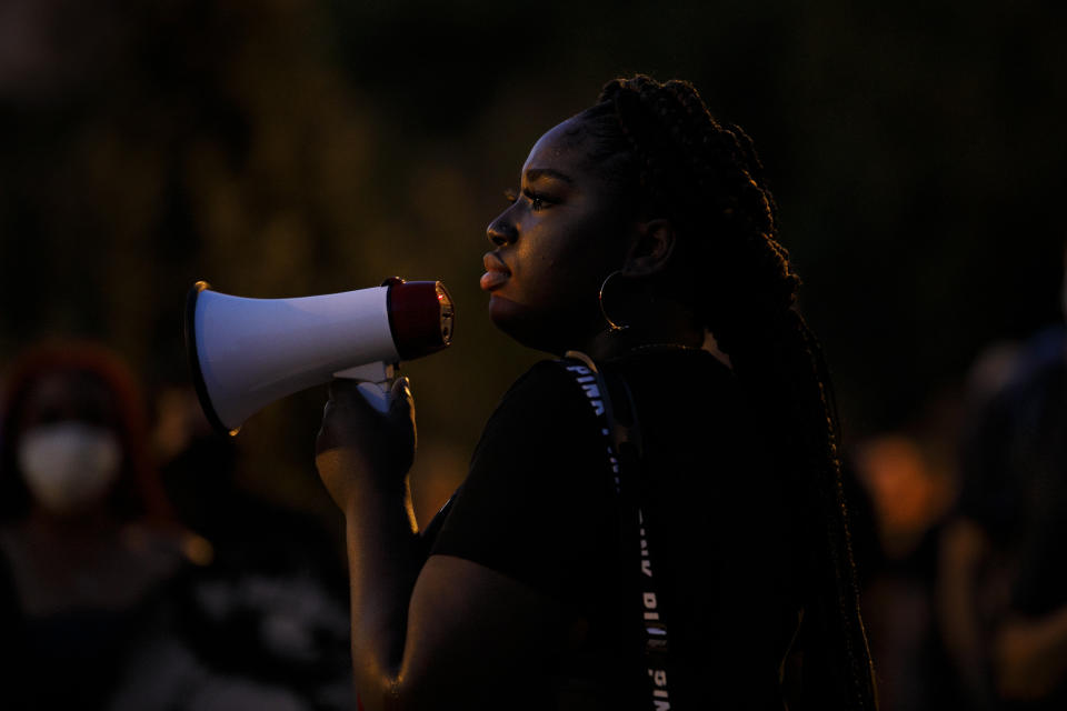 In this June 12, 2020, photo, Joella Roberts, 22, of Washington, who is a recipient of the Deferred Action for Childhood Arrivals, or DACA, program and is originally from Trinidad and Tobago, leads a protest near the White House in Washington, over the death of George Floyd, a black man who was in police custody in Minneapolis. On Thursday, June 18, the U.S. Supreme Court kept alive the Obama-era program that allows immigrants brought here as children to work and protects them from deportation. (AP Photo/Jacquelyn Martin)