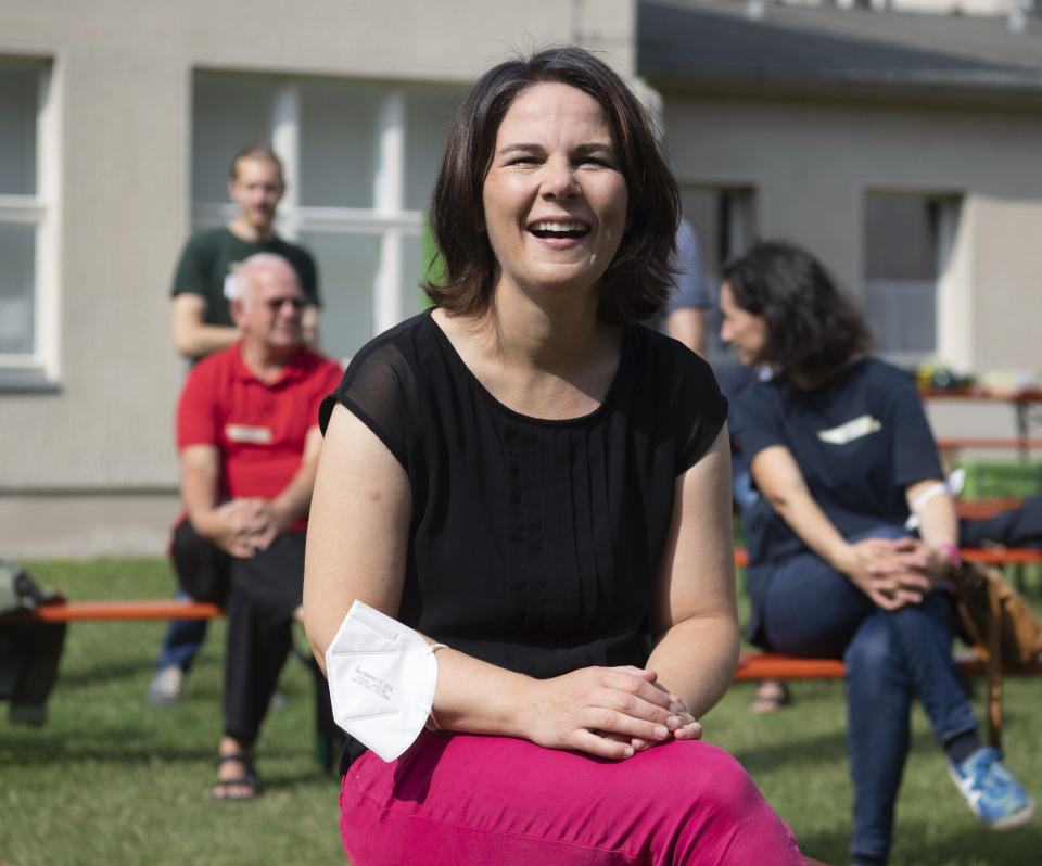 Annalena Baerbock, top canditate of the German Green party for the federal elections, smiles as she visits the central campaign camp in Brandenburg near Berlin, Germany, Saturday Aug. 21, 2021. A large chunk of the German electorate remains undecided going into an election that will determine who succeeds Angela Merkel as chancellor after 16 years in power. Recent surveys show that support for German political parties has flattened out, with none forecast to receive more than a quarter of the vote. (Paul Zinken/dpa via AP)