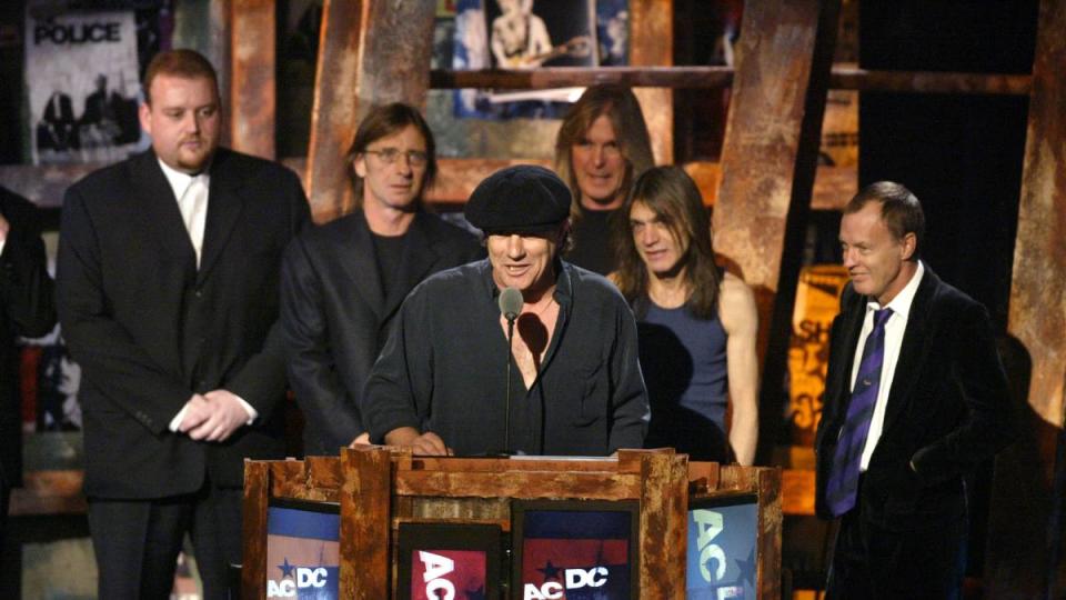 Man at podium speaking, others behind him