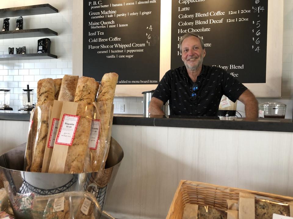Joe Deveau, the manager of the new market at The Colony in Kennebunkport, Maine, is seen here among the fresh loaves of bread for sale on Monday, Aug. 7, 2023.