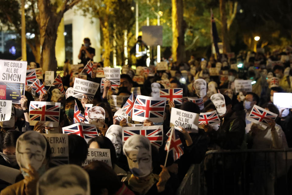 Protesters wear masks of Simon Cheng, a Hong Kong British Consulate employee who was detained in China, as they gather for a rally outside of the British Consulate in Hong Kong, Friday, Nov. 29, 2019. Hong Kong police ended their blockade of a university campus Friday after surrounding it for 12 days to try to arrest anti-government protesters holed up inside. (AP Photo/Vincent Thian)