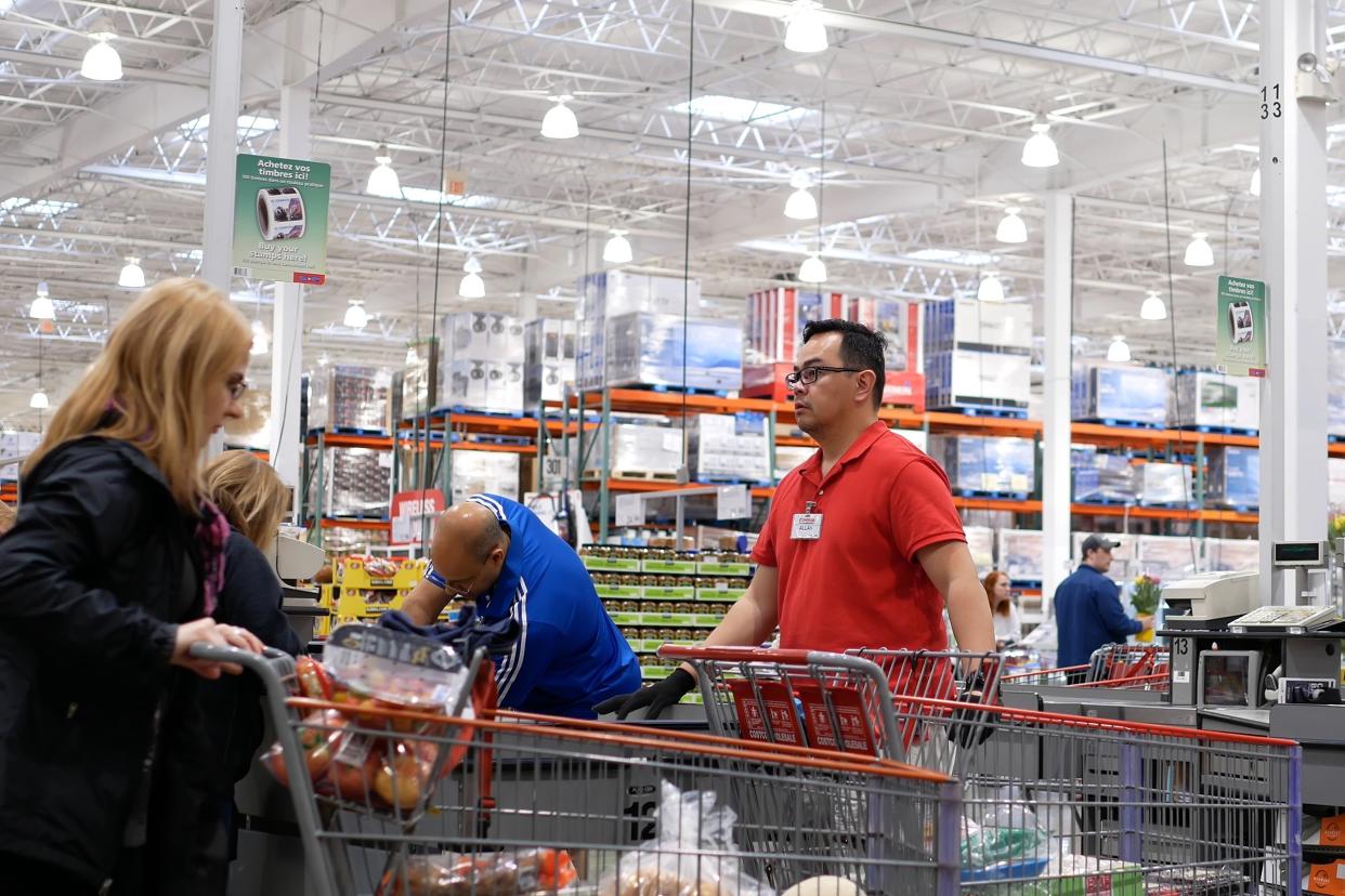 cashier scanning food and stocking them on trolley at check out counter inside Costco