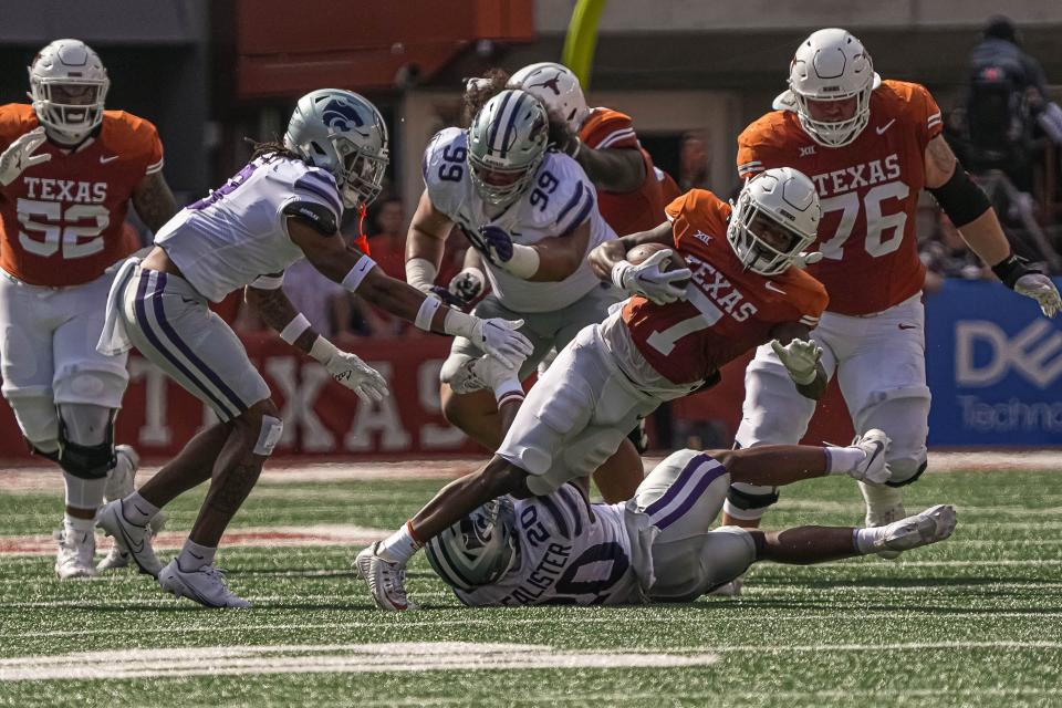 Texas running back Keilan Robinson (7) is tripped while running the ball against Kansas State at Royal-Memorial Stadium on Saturday, Nov. 4, 2023 in Austin.