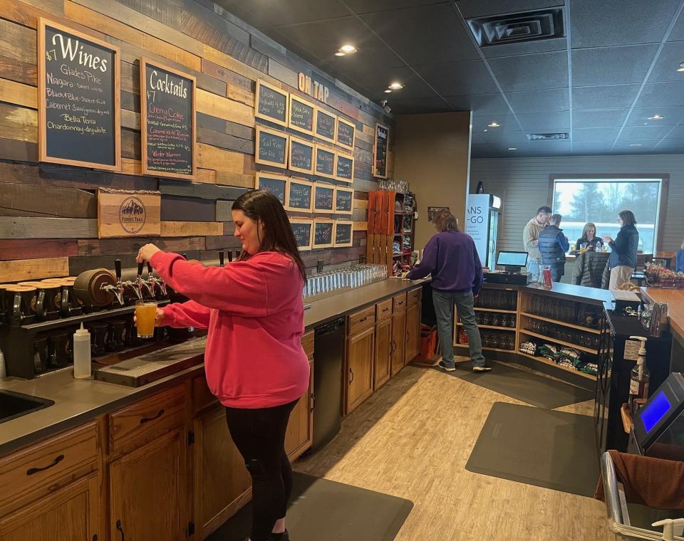 Kaitlin Fahy, in foreground, pours a glass of Forbes Trail Brewing's Kolsch Calm & Collected during the Pour Tour 4.0 kickoff. Fahy's mother, Kathy Smith, in the background, works behind the bar as well.