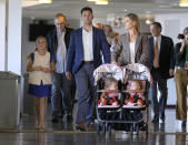 San Francisco Giants catcher Buster Posey and his wife, Kristen, arrive with their children, joined by former manager Bruce Bochy, second from left, and Giants CEO Larry Baer, right, for a news conference announcing his retirement from baseball, Thursday, Nov. 4, 2021, in San Francisco. (AP Photo/Tony Avelar)