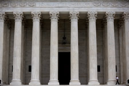 FILE PHOTO: A police officer walks by columns at the Supreme Court in Washington