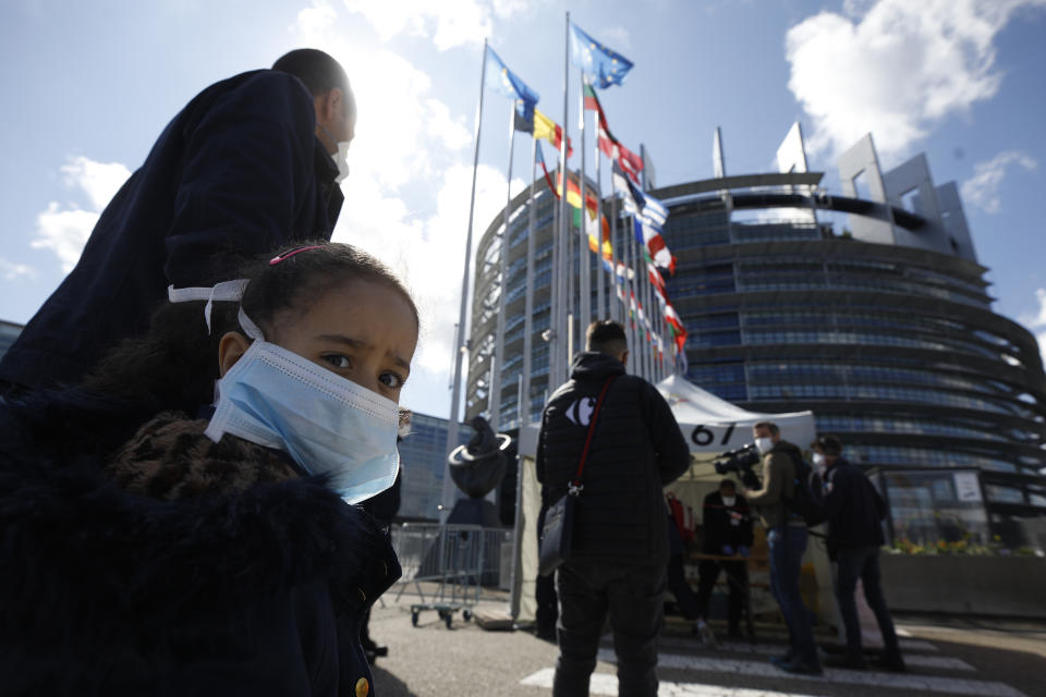 FILE - In this Tuesday, May 12, 2020 file photo, people wait in line to be tested for the COVID-19 outside the European Parliament in Strasbourg, eastern France. European lawmakers won’t be returning to the French city of Strasbourg for next week’s plenary session because of the COVID-19 worrying situation in France. The European Parliament President David Sassoli said Thursday, Oct. 15, 2020, the session will be held remotely. Plenary sessions scheduled in Strasbourg, which is the official seat of the European Parliament, have been scrapped since March because of concerns related to the coronavirus. (AP Photo/Jean-Francois Badias, File)