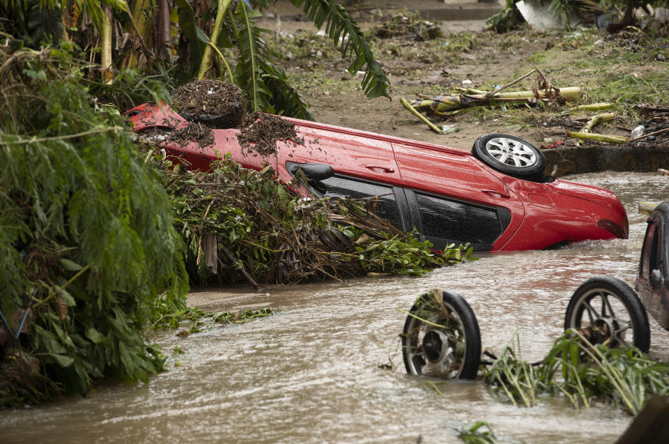 Vehicles that were carried away in flash floods after heavy rains lay in a creek in the Realengo neighborhood of Rio de Janeiro, Brazil, Monday, March 2, 2020. The water flooded the streets and entered homes of residents, with at least 4 deaths reported. (AP Photo/Silvia Izquierdo)