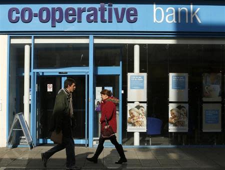 People pass a Co-operative Bank in Brighton in southern England February 26, 2014. REUTERS/Luke MacGregor