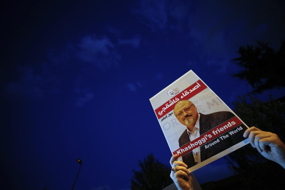 Activists protesting the killing of Saudi journalist Jamal Khashoggi hold a candlelight vigil outside Saudi Arabia's consulate in Istanbul, Thursday, Oct. 25, 2018. The poster reads in Arabic:' Khashoggi's Friends Around the World'. A group of Arab and international public, political and media figures are establishing a global association called "Khashoggi's Friends Around the World"; "to achieve justice for the freedom martyr".(AP Photo/Emrah Gurel)