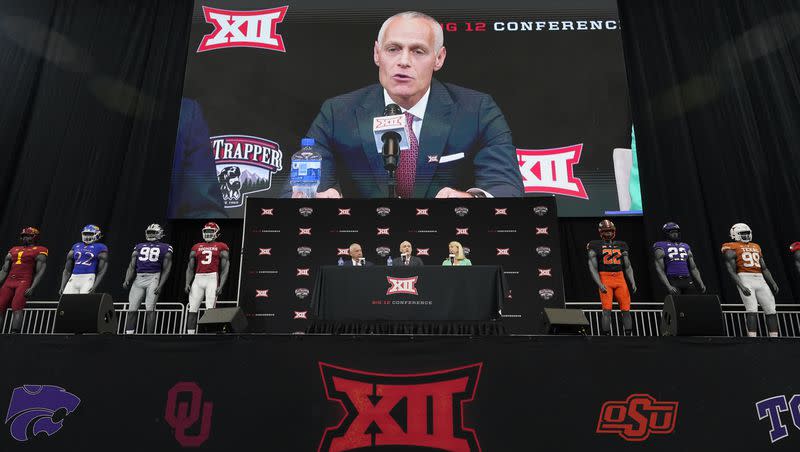 Incoming Big 12 commissioner Brett Yormark, center, speaks with outgoing commissioner Bob Bowlsby, left, and Baylor president Linda Livingstone looking on during a news conference opening the NCAA college football Big 12 media days in Arlington, Texas, Wednesday, July 13, 2022. 