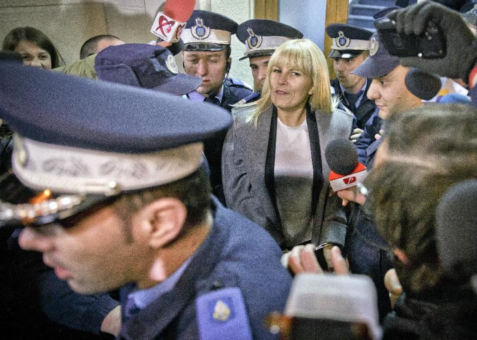 FILE - In this Tuesday, Feb. 10, 2015 file photo, Elena Udrea a 41-year-old Romanian politician who gained notoriety due to her close relationship with Traian Basescu, Romania's president from 2004 to 2014, is escorted by policemen as she exits the anti-corruption prosecutor's office in Bucharest, Romania. Elena Udrea is probably the most powerful woman politician of the last decade, although she failed to win a seat in Parliament in Dec. 2016 elections. (AP Photo/Vadim Ghirda, file)