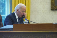 In this image made through a window, President Joe Biden talks on the phone with Ukrainian President Volodymyr Zelenskyy from the Oval Office of the White House in Washington, Thursday, Dec. 9, 2021. (AP Photo/Susan Walsh)