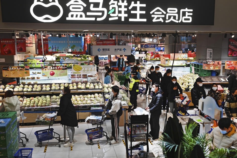 In this photo released by Xinhua News Agency, residents wearing face masks to protect from the coronavirus shop for groceries at a supermarket in Qujiang New District of Xi'an in northwestern China's Shaanxi Province on Jan. 15, 2022. The Chinese city of Xi'an has gradually begun lifting restrictions after over three weeks of lockdown as authorities sought to stamp out a local outbreak before the Beijing Winter Olympic Games are due to start. (Tao Ming/Xinhua via AP)