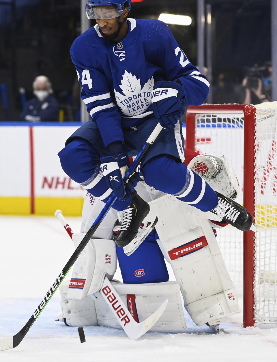 Toronto Maple Leafs forward Wayne Simmonds (24) jumps as he screens Montreal Canadiens goaltender Jake Allen (34) on a shot during the first period of an NHL hockey game Wednesday, April 7, 2021, in Toronto. (Nathan Denette/The Canadian Press via AP)