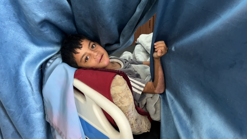 Young boy lies on a hospital bed