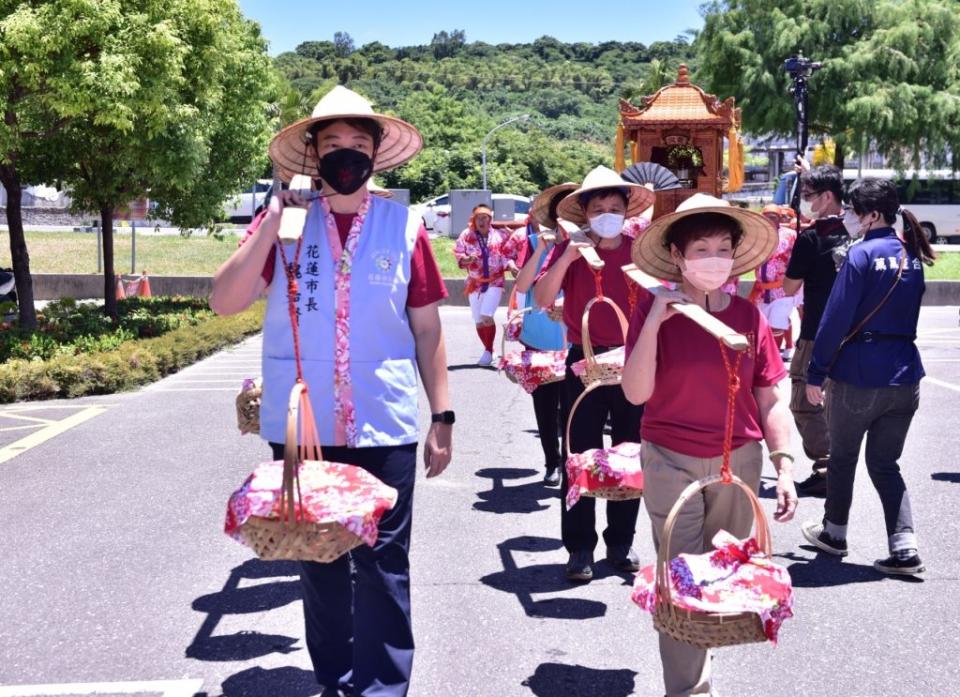 花蓮市長魏嘉賢、代表會主席蘇美珠等人擔任挑擔人員，迎接義民爺鑾轎。（花蓮市公所提供）