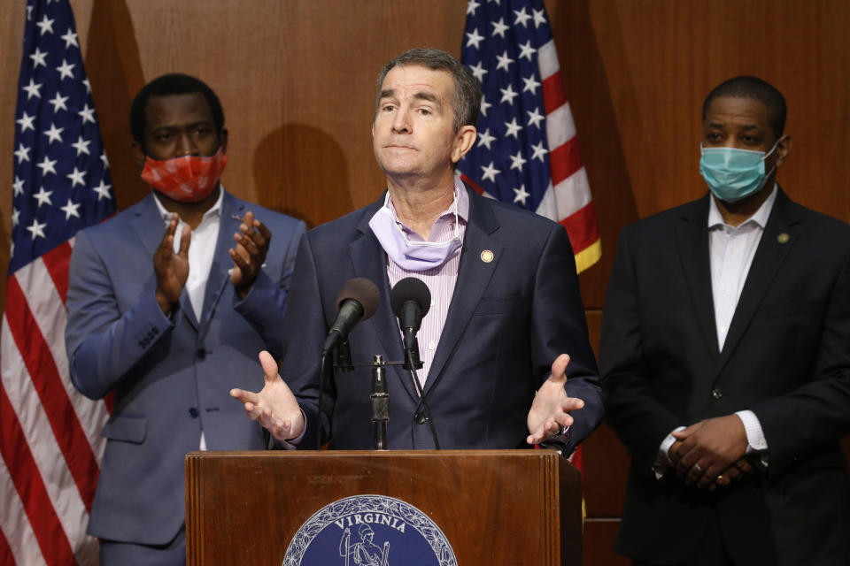 Virginia Gov. Ralph Northam, center, gestures as he announces his plans to remove the statue of Confederate General Robert E. Lee on Monument Avenue while Richmond Mayor Levar Stoney, left, and Lt. Gov. Justin Fairfax, right, look on, Thursday, June 4, 2020, in Richmond, Va. (AP Photo/Steve Helber)