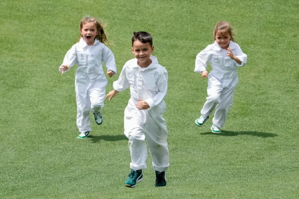 Apr 10, 2024; Augusta, Georgia, USA; Jax Woodland is chased by his sisters, Maddox and Lennox, down the no. 4 fairway during the Par 3 Contest at Augusta National Golf Club. Mandatory Credit: Michael Madrid-USA TODAY Network