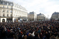 A crowd listens to musicians performing outside the Palais Garnier opera house, Saturday, Jan. 18, 2020 in Paris. As some strikers return to work, with notable improvements for train services that have been severely disrupted for weeks, more radical protesters are trying to keep the movement going. (AP Photo/Thibault Camus)