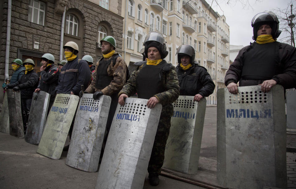 Protesters stand guard in front of presidential administrative building in central Kiev, Ukraine, Saturday, Feb. 22, 2014. Protesters in the Ukrainian capital claimed full control of the city Saturday following the signing of a Western-brokered peace deal aimed at ending the nation's three-month political crisis. The nation's embattled president, Viktor Yanukovych, reportedly had fled the capital for his support base in Ukraine's Russia-leaning east. (AP Photo/Darko Bandic)