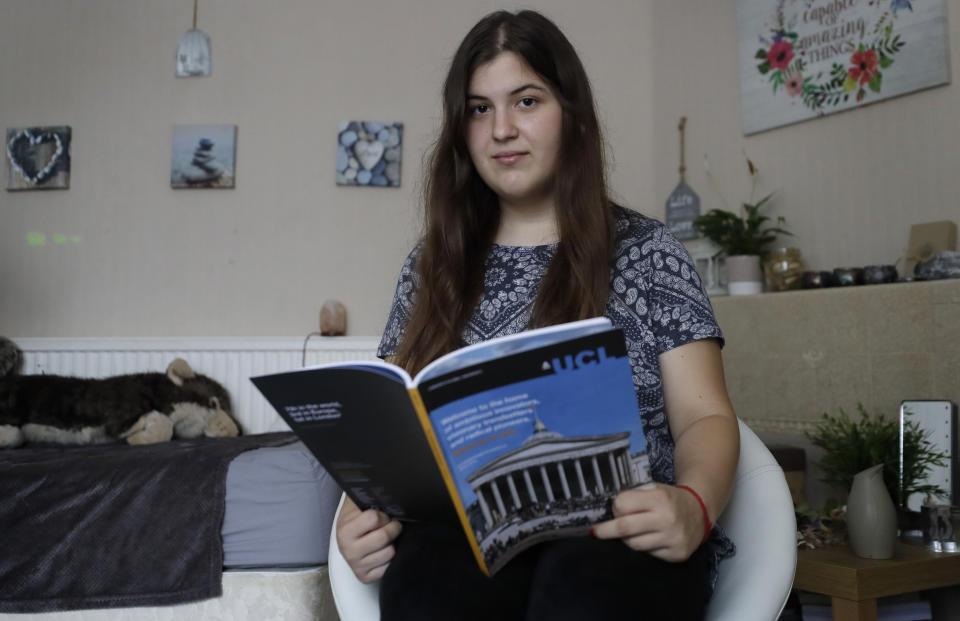 A-Level student and would be medical student Kaya Ilska looks at a prospectus for University College London (UCL), the University that she had been offered a place at, poses at home in London, Wednesday, Aug. 19, 2020. Thousands of graduating high school students in Britain are scrambling for university places following the government’s disastrous decision to award final grades using an unfair algorithm to replace exams canceled because of the coronavirus, resulting in mass confusion. Ilska was confident of excelling in her A Level exams but was robbed of the opportunity. (AP Photo/Kirsty Wigglesworth)