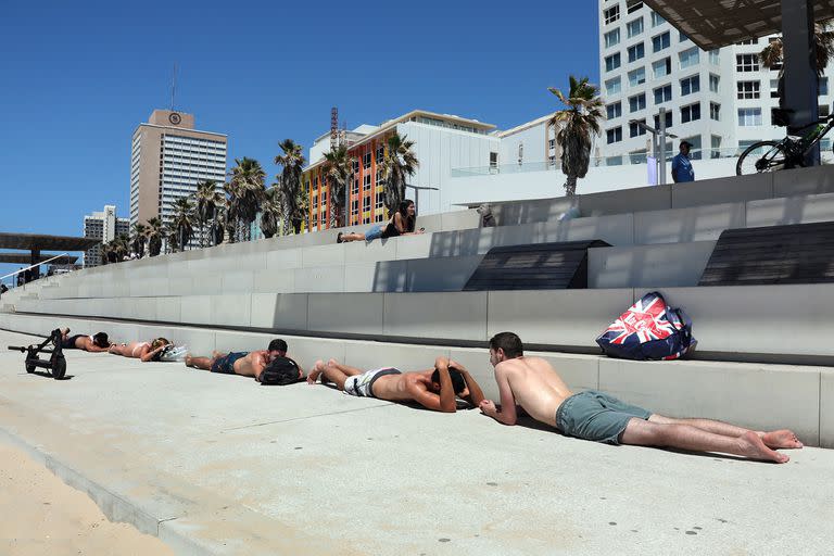 Los bañistas israelíes se refugian en la ciudad central de Tel Aviv, el 15 de mayo de 2021, tras el lanzamiento de cohetes desde la Franja de Gaza controlada por el movimiento palestino Hamas hacia Israel.