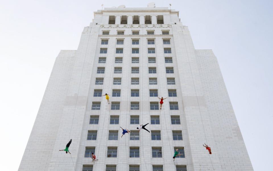 Aerial dancers from Bandaloop perform on the side of the City Hall building during "La La Land Day" - Credit: EUGENE GARCIA /EPA