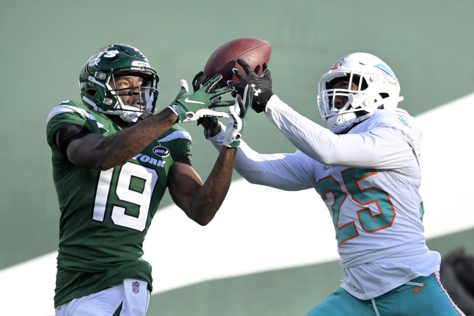 Miami Dolphins cornerback Xavien Howard (25) breaks up a s pass intended for New York Jets wide receiver Breshad Perriman (19) during the first half of an NFL football game, Sunday, Nov. 29, 2020, in East Rutherford, N.J. Howard leads the NFL this season with seven interceptions, and his shutdown skills have helped the Dolphins flummox foes with a blitz-happy scheme. He's the chief catalyst in a remarkable turnaround by Miami’s defense over the past 12 months.(AP Photo/Bill Kostroun)