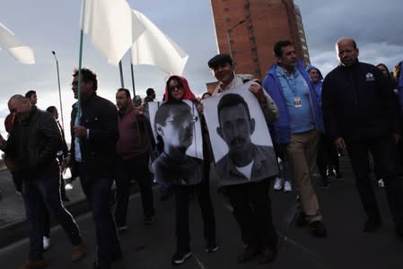 People hold posters with photographs of murdered Colombian social leaders, during a protest against the killing of social activists, in Bogota