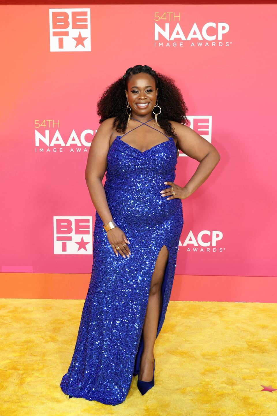 Bria Henderson at the 2023 NAACP Image Awards in a sparkling blue gown and pointed-toe heels.