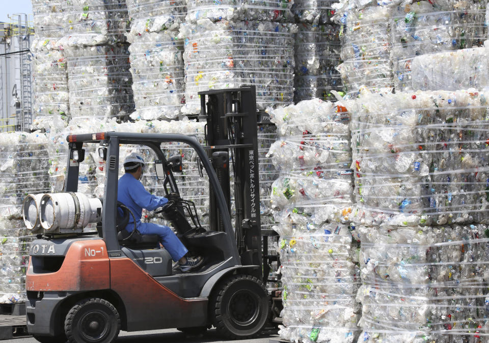 In this June 18, 2019, photo, a plastic recycling company worker on a forklift truck moves a pile of plastic bottles collected for processing at Tokyo Petbottle Recycle Co., Ltd, in Tokyo. Japan has a plastic problem. Single bananas here are sometimes wrapped in plastic. So are individual pieces of vegetables, fruit, pastries, pens and cosmetics. Plastic-wrapped plastic spoons come with every ice cream cup. But as world leaders descend on Osaka for the two-day G20 Summit that starts Friday, June 28, Japan has ambitions to become a world leader in reducing plastic waste. (AP Photo/Koji Sasahara)