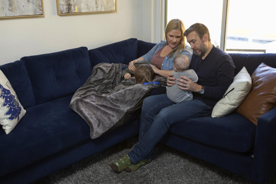 Kaitlyn Kash and husband Cory Kash sit at home with their 5-year-old son and 4-month-old daughter, Sunday, Dec. 17, 2023, in Austin, Texas. Kaitlyn Kash has joined as a plaintiff on the Zurawski v. State of Texas case, a lawsuit that looks to clarify the scope of the state's abortion ban. (AP Photo/Stephen Spillman)