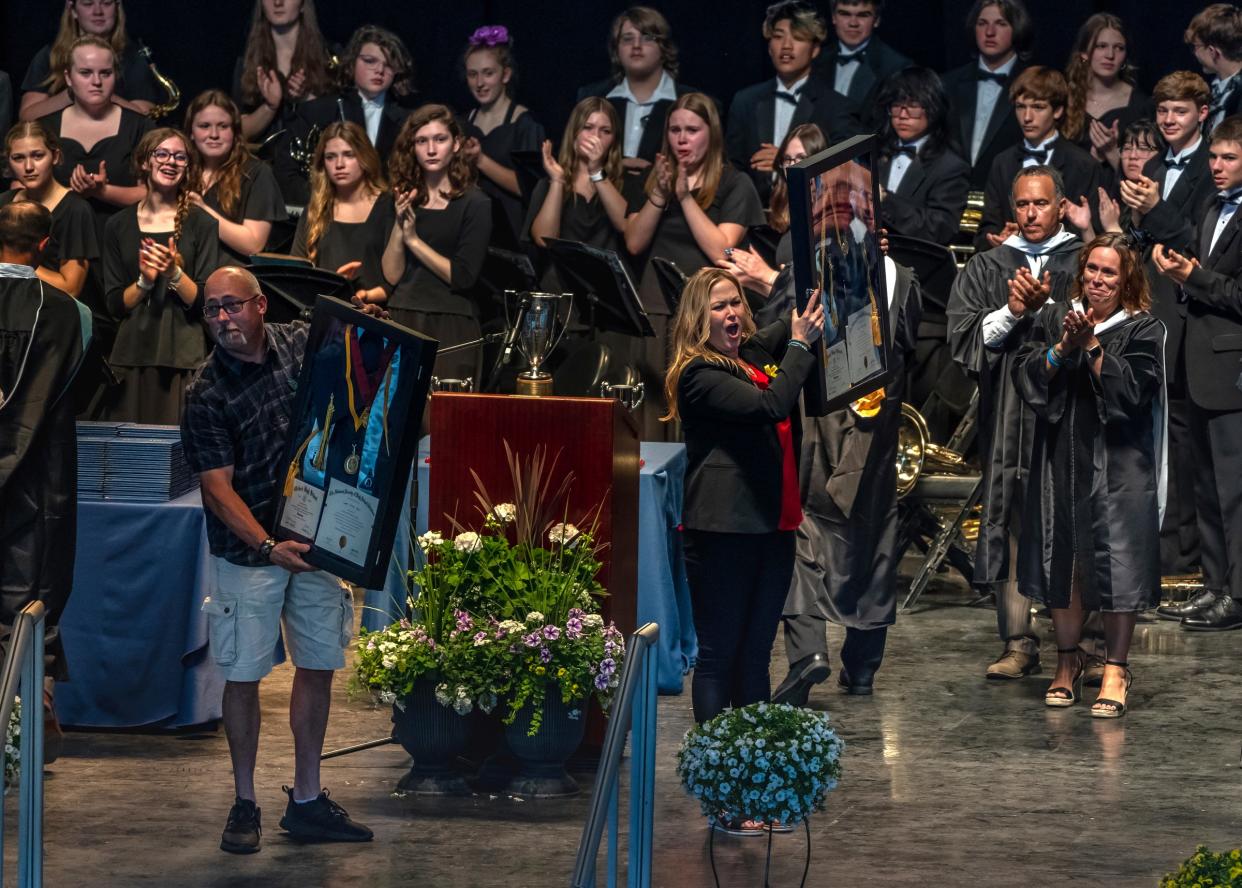 Jill Soave and Craig Shilling hold cap and gowns framed with the degree for their son the late Oxford High School senior Justin Shilling, who was one of four students killed during a school shooting at Oxford High School, after being presented with the items during the graduation ceremony for Oxford High School class of 2022 at Pine Knob Music Theater in Clarkston, Michigan, on Thursday, May 19, 2022.