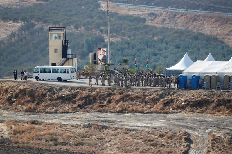 Jordanian soldiers gather near a tent and a picture depicting Jordanian King Abdullah and his father, late King Hussein, in the border area between Israel and Jordan, as seen from the Israeli side