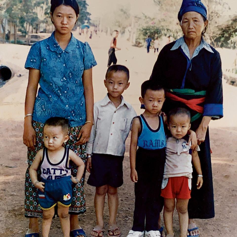 Vang (bottom right) with family at Ban Vinai, the refugee camp where he was born.