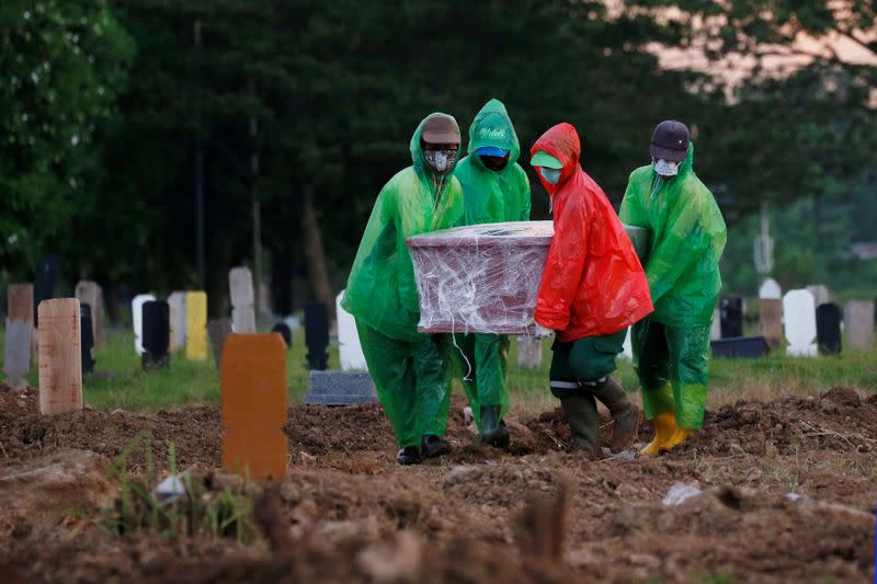 FILE PHOTO: Municipality workers carry the coffin of Ratih Purwarini, a doctor who passed away due to the coronavirus disease (COVID-19), during a funeral in Jakarta