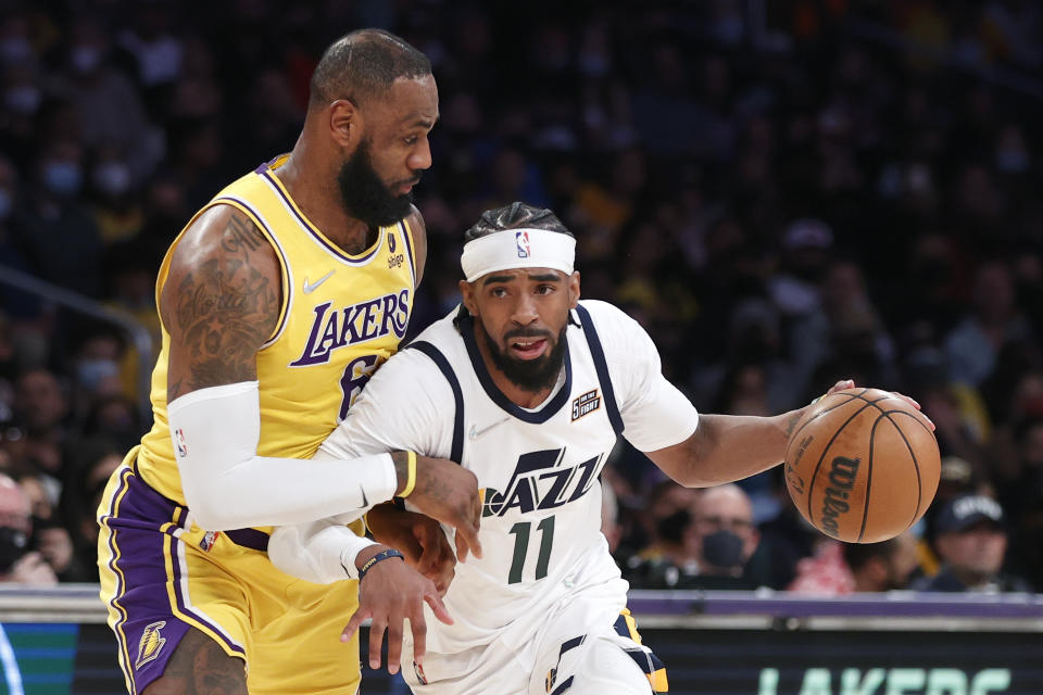 Utah Jazz guard Mike Conley (11) drives past Los Angeles Lakers forward LeBron James (6) during the first half of an NBA basketball game in Los Angeles, Monday, Jan. 17, 2022. (AP Photo/Ringo H.W. Chiu)