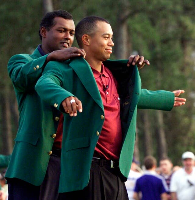 Tiger Woods, right, receives his Masters green jacket from Vijay Singh in 2001