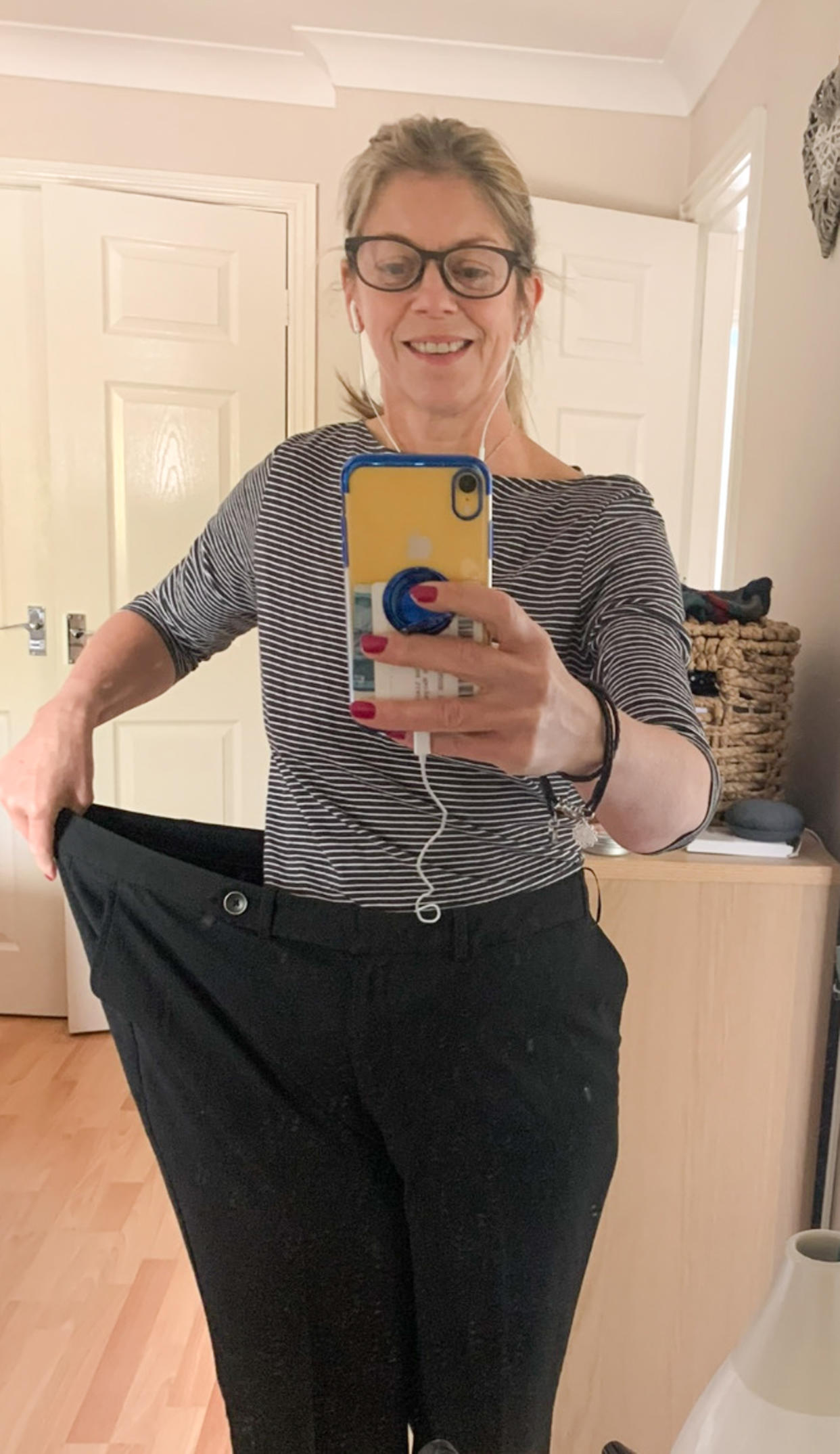 Cath Davies wearing an old pair of trousers after her weight loss. (Caters)