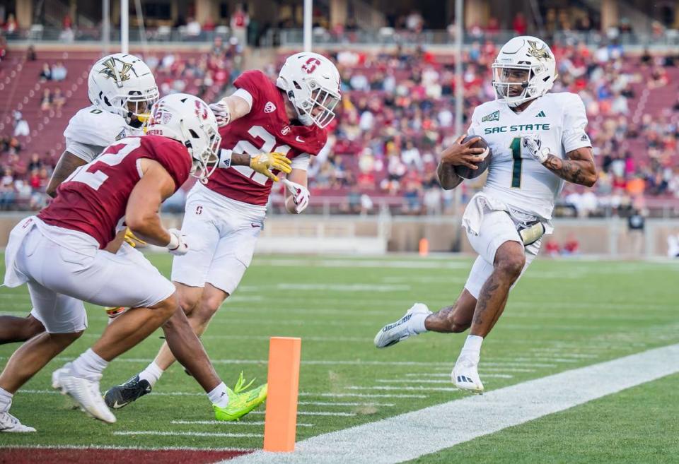 Sacramento State Hornets quarterback Kaiden Bennett (1) runs out of bounds as he scrambles for yards, scoring later on another run, as Stanford Cardinal safety Scotty Edwards (21), center, covers him in September at Stanford University.